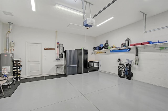 garage featuring a garage door opener, freestanding refrigerator, gas water heater, and visible vents