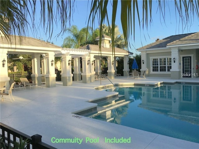 community pool with a patio, an outdoor structure, and an exterior structure