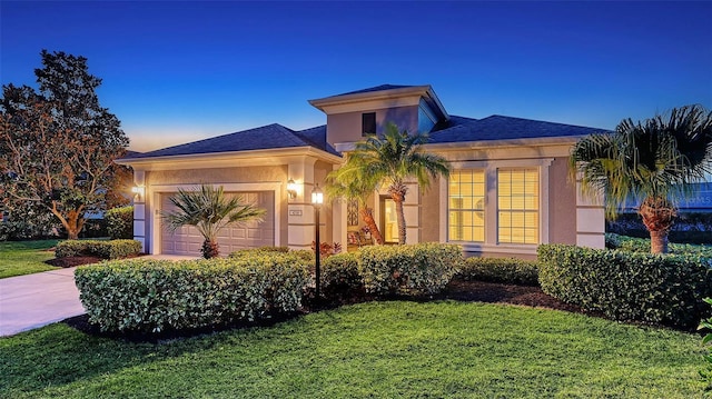 view of front of property featuring a garage, a front yard, driveway, and stucco siding