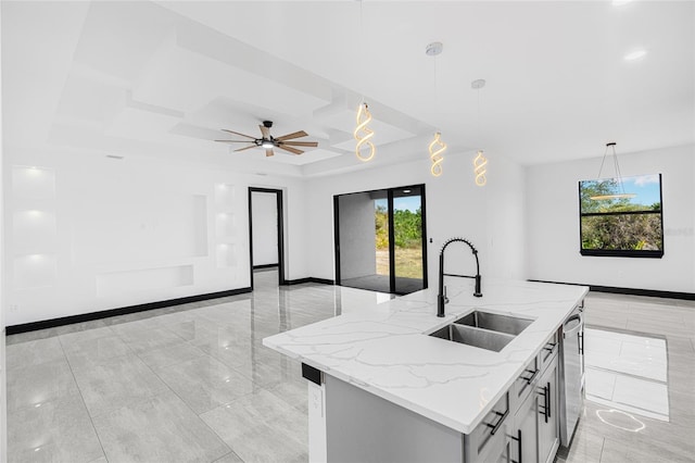 kitchen with pendant lighting, a sink, open floor plan, and an island with sink