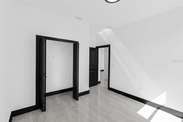 unfurnished bedroom featuring a closet, visible vents, and baseboards