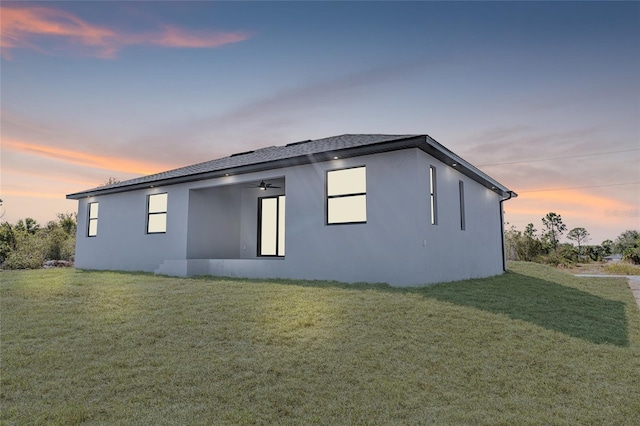 view of property exterior with a lawn and stucco siding