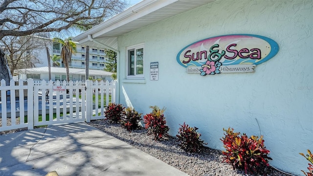 property entrance with fence and stucco siding