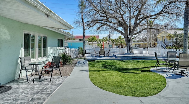 surrounding community featuring fence, a patio, and a yard
