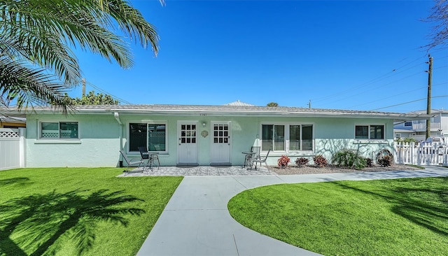 ranch-style home with fence, a front lawn, and stucco siding