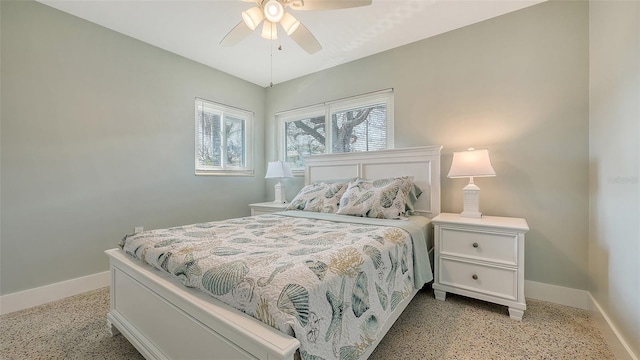 bedroom with light speckled floor, ceiling fan, and baseboards