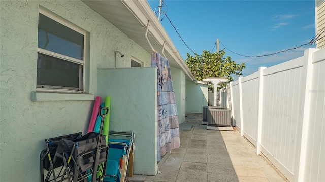 view of home's exterior featuring fence, central AC unit, and stucco siding