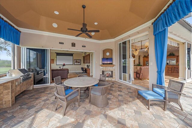 view of patio / terrace featuring ceiling fan, an outdoor stone fireplace, and area for grilling