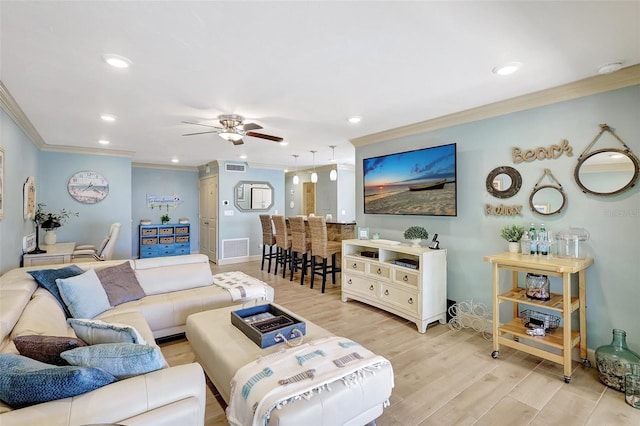 living area with ceiling fan, light wood-style flooring, recessed lighting, visible vents, and crown molding