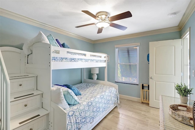 bedroom with light wood finished floors, ornamental molding, a ceiling fan, and baseboards