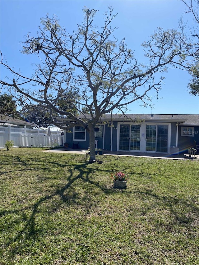 back of house with a lawn and fence