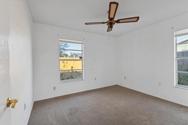 empty room featuring carpet flooring, a ceiling fan, and baseboards