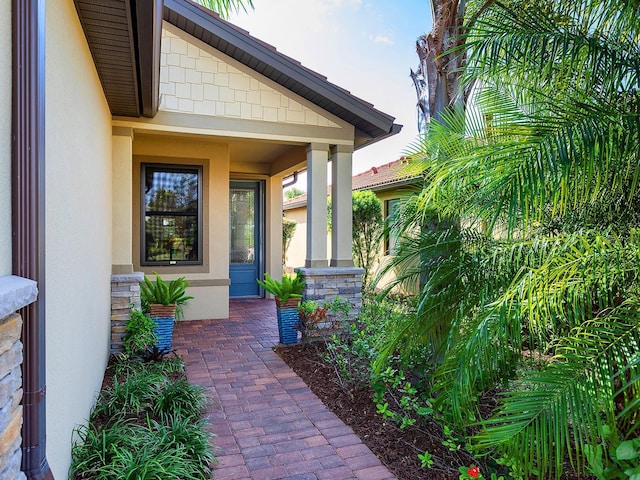 view of exterior entry with stone siding and stucco siding