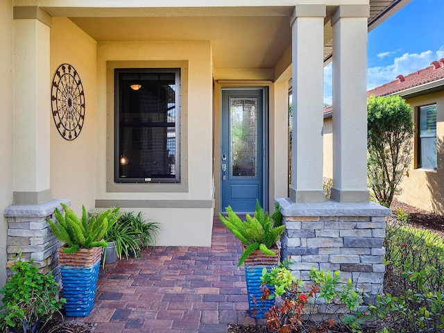 view of exterior entry featuring stucco siding