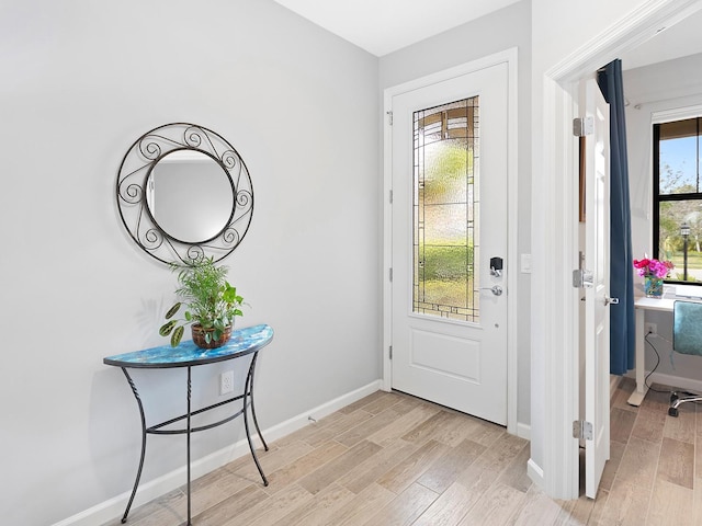 foyer entrance featuring light wood finished floors and baseboards