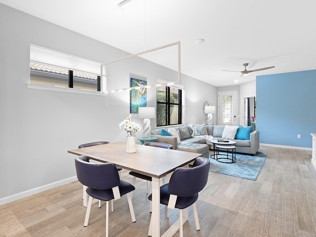 dining space with light wood-style flooring, baseboards, and ceiling fan