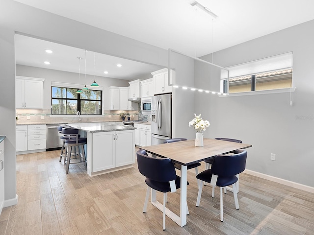 dining space featuring recessed lighting, light wood-type flooring, and baseboards