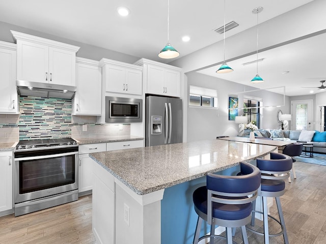 kitchen featuring stainless steel appliances, visible vents, open floor plan, white cabinetry, and under cabinet range hood