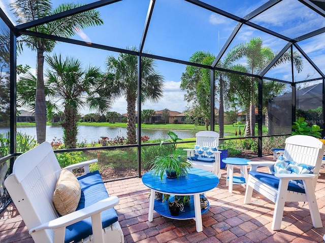 view of patio featuring glass enclosure and a water view