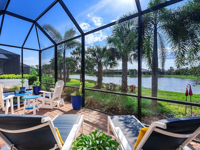 sunroom featuring a water view