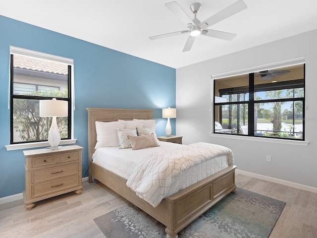 bedroom with light wood-style flooring, baseboards, and ceiling fan