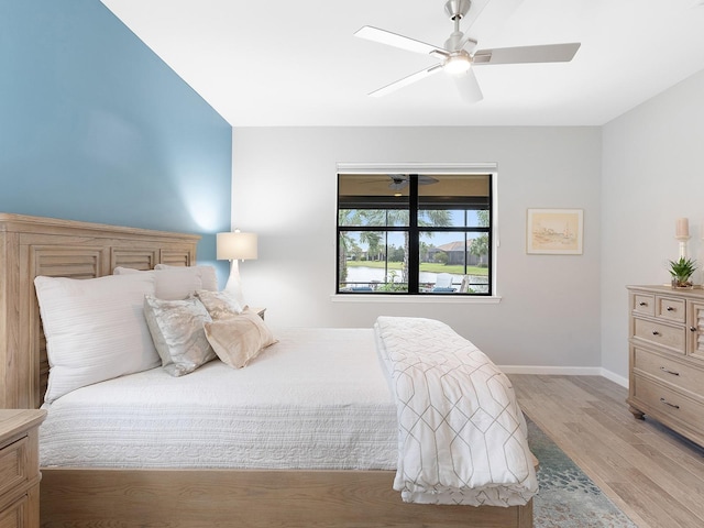 bedroom with light wood-style floors, baseboards, and a ceiling fan