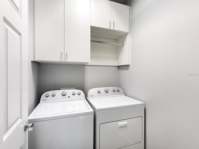 laundry area featuring separate washer and dryer and cabinet space