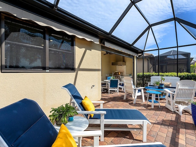 view of patio / terrace featuring outdoor dining space, a lanai, and a ceiling fan