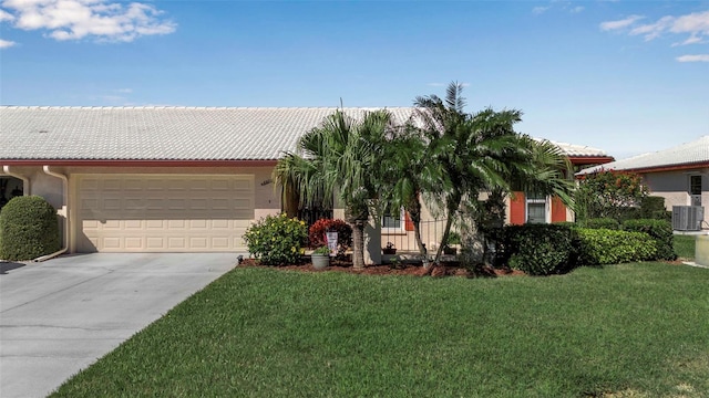 view of front of house featuring concrete driveway, a front lawn, an attached garage, and central air condition unit