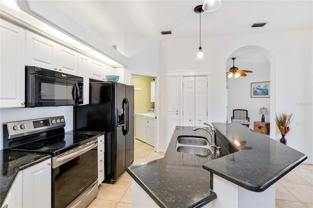 kitchen featuring black appliances, a sink, independent washer and dryer, light tile patterned floors, and an island with sink