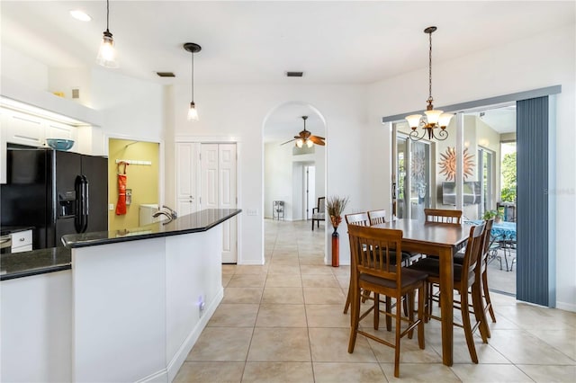 dining space with a ceiling fan, light tile patterned floors, a chandelier, and baseboards