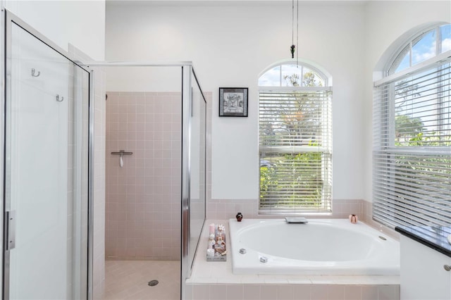 full bath featuring a bath and a stall shower