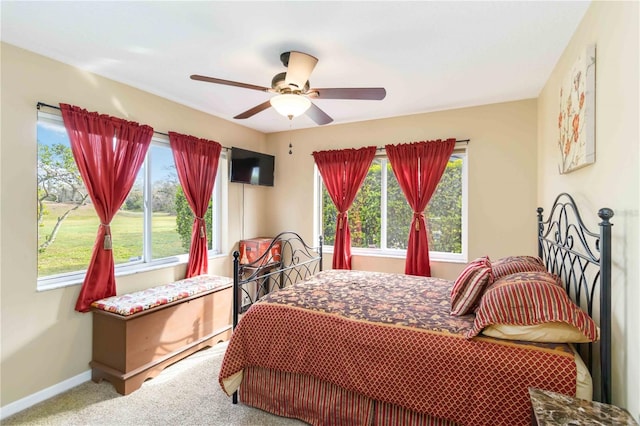 bedroom featuring multiple windows, carpet floors, baseboards, and a ceiling fan