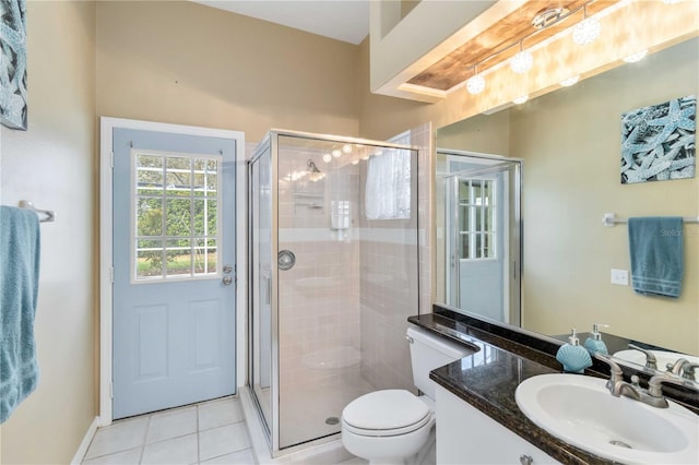 bathroom featuring a stall shower, tile patterned floors, toilet, vanity, and baseboards