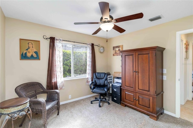 home office featuring a ceiling fan, light carpet, and baseboards