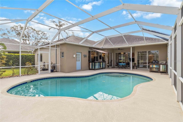 swimming pool featuring a patio area, ceiling fan, and a lanai