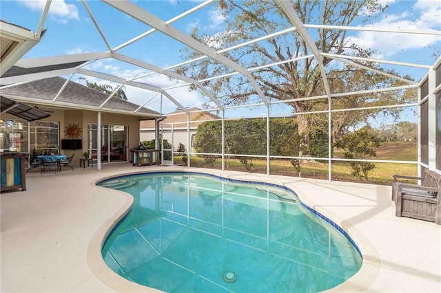 swimming pool with a patio area and glass enclosure