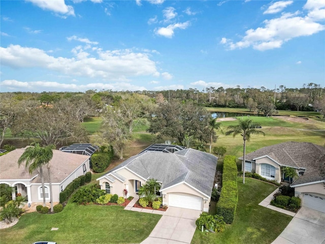 aerial view of property and surrounding area featuring a tree filled landscape, a nearby body of water, and a golf club