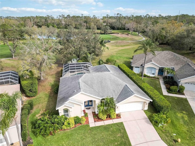 view from above of property with a tree filled landscape and a local golf course