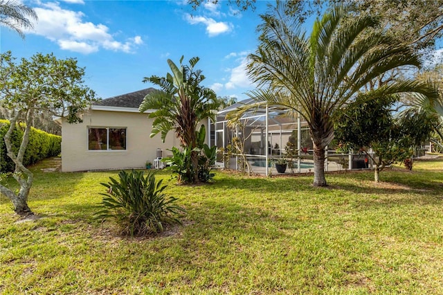 view of grassy yard with an outdoor pool and glass enclosure