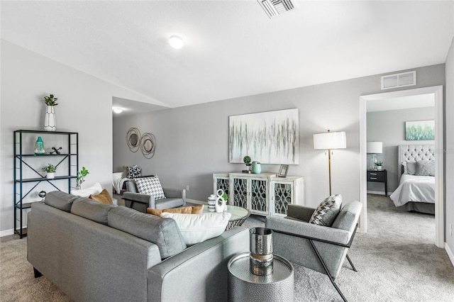 living room with light carpet, baseboards, visible vents, and vaulted ceiling