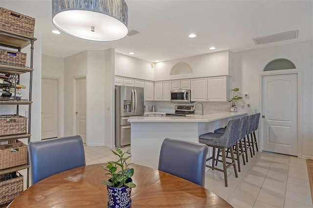 dining space with light tile patterned floors, visible vents, and recessed lighting