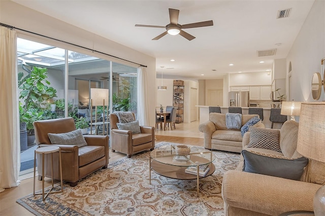 living area with light wood-type flooring, visible vents, a ceiling fan, and recessed lighting