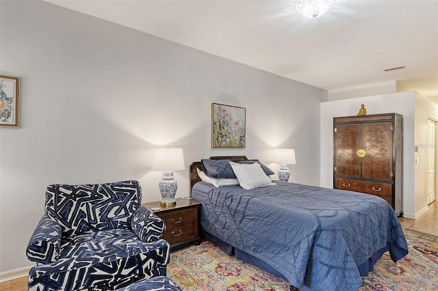 bedroom with visible vents, light wood-style flooring, and baseboards