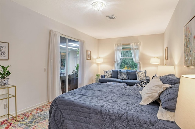 bedroom with access to outside, visible vents, and baseboards