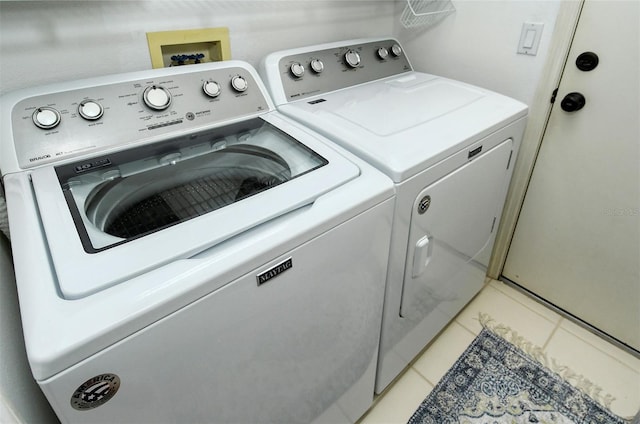 laundry room featuring laundry area, light tile patterned flooring, and separate washer and dryer