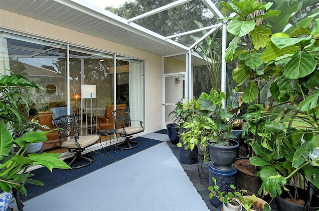 view of patio featuring glass enclosure