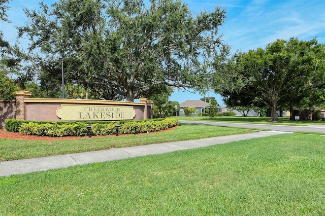 community / neighborhood sign featuring a yard