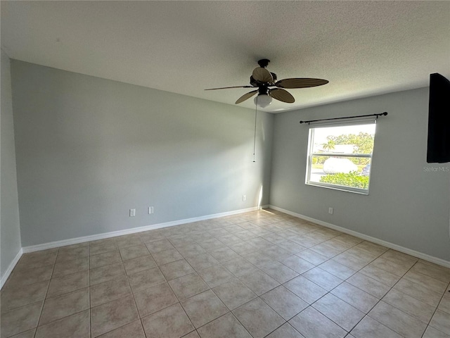 spare room featuring ceiling fan, a textured ceiling, and baseboards