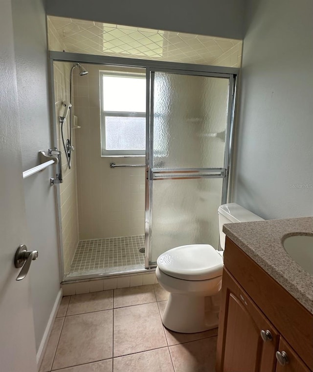 full bath with toilet, a stall shower, tile patterned flooring, and vanity